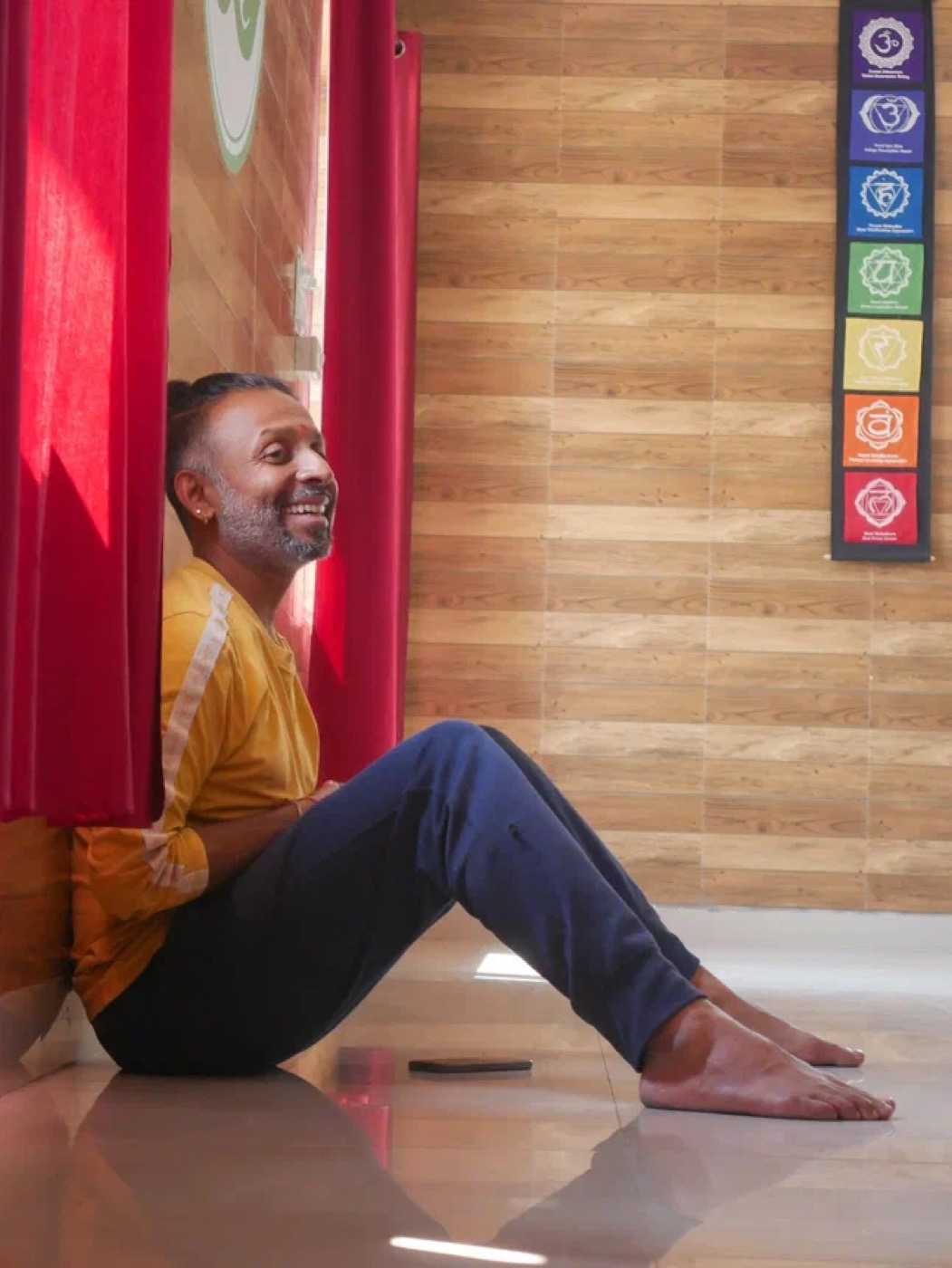 Parveen Nair against a red curtain in the Rishikesh shala