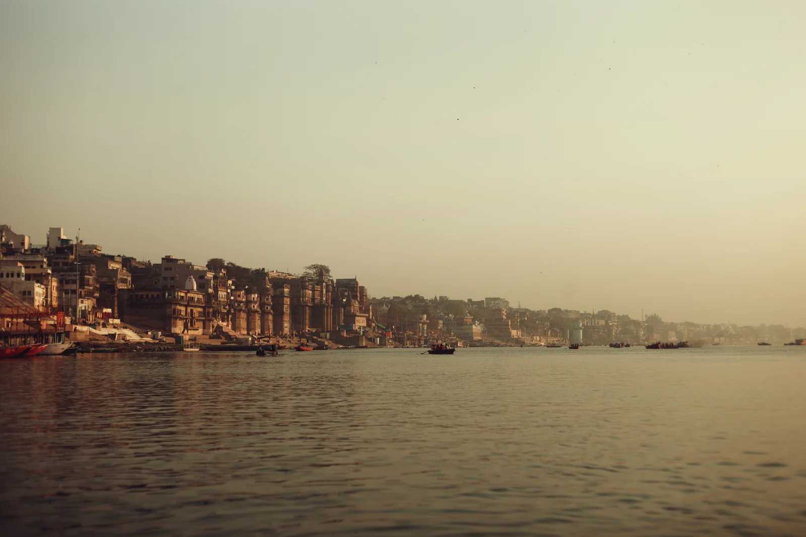 A river city at dusk, the ghats running down to the water
