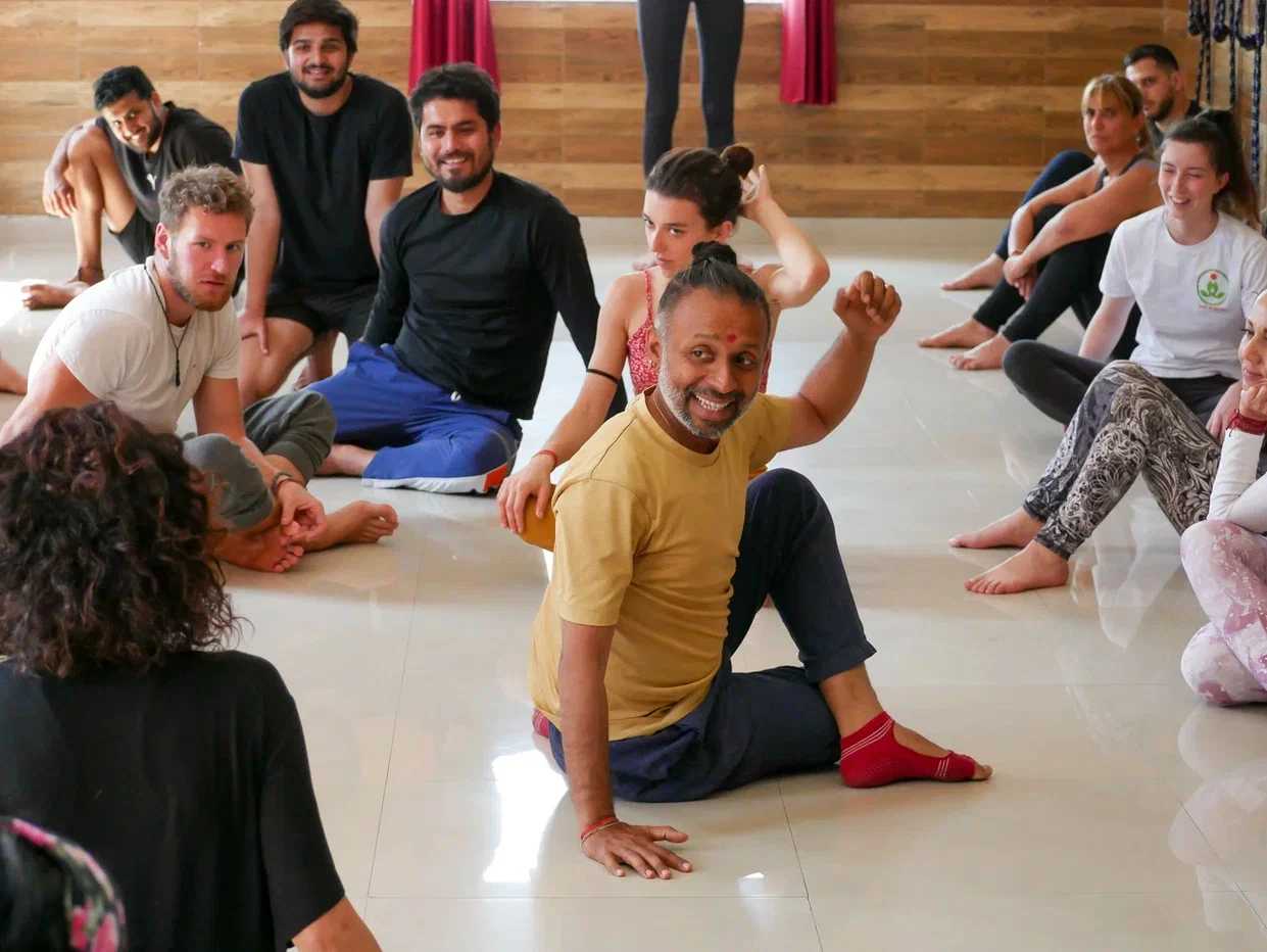 Parveen Nair teaching a circle of students seated on the floor