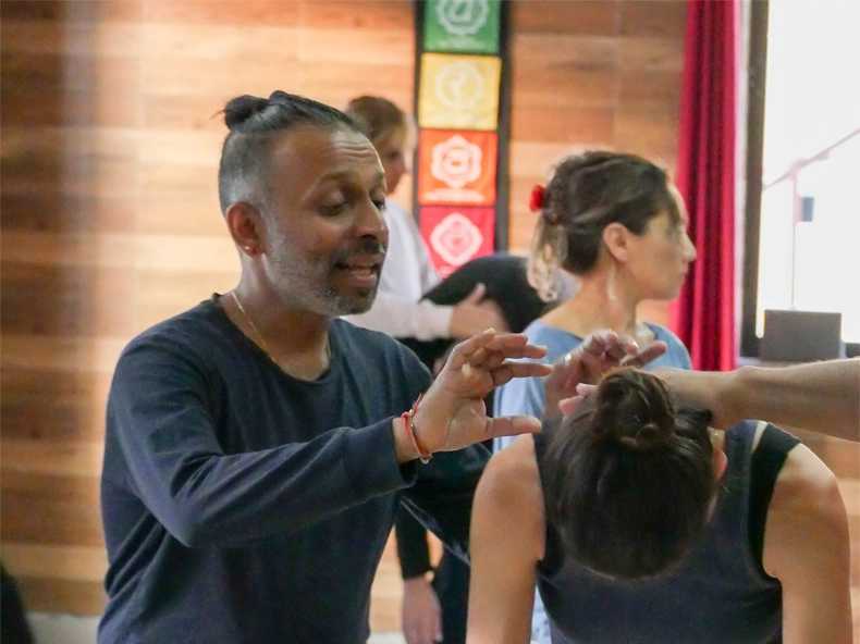 Parveen Nair demonstrating a movement with his hands during a training in Rishikesh